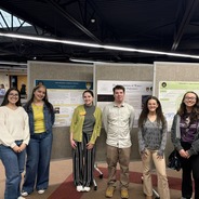 6 LCCC students standing in front of 3 posters at the LCCC arts and scholars showcase